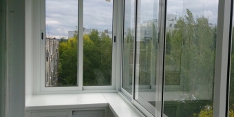 Холодное остекление Г - образного балкона с обшивкой пластиковыми панелями и встроенным шкафом.